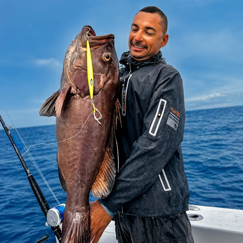 Angler holding brown fish catch during private inshore fishing charter