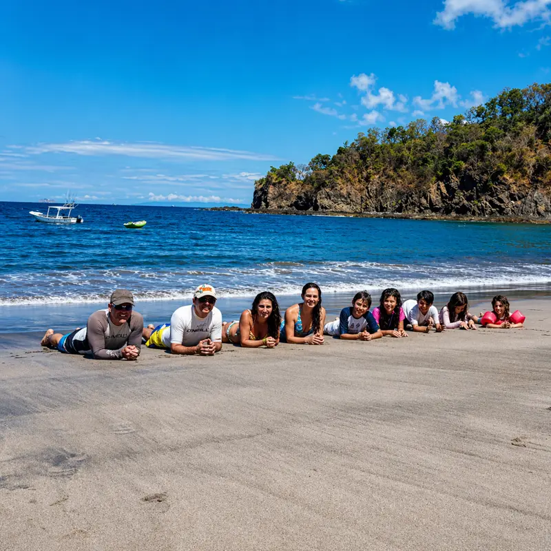 Group relaxing on secluded sandy beach during custom private boat tour