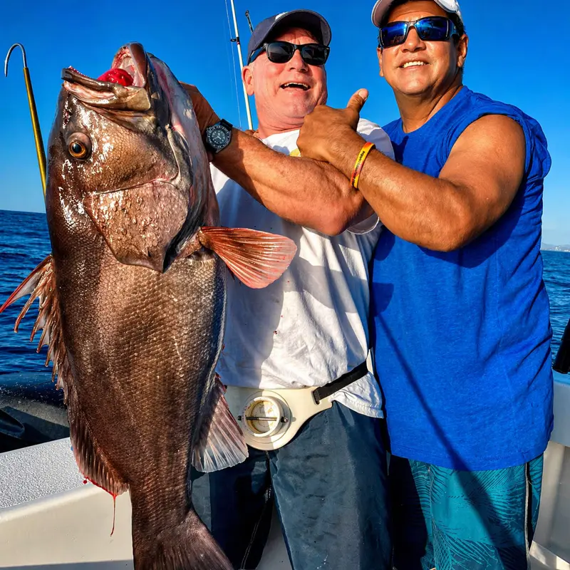 Two men proudly displaying catches during an offshore sportfishing trip from Tamarindo